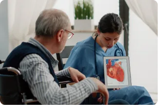 A clinician showing a heart image on a tablet to a patient in a wheelchair