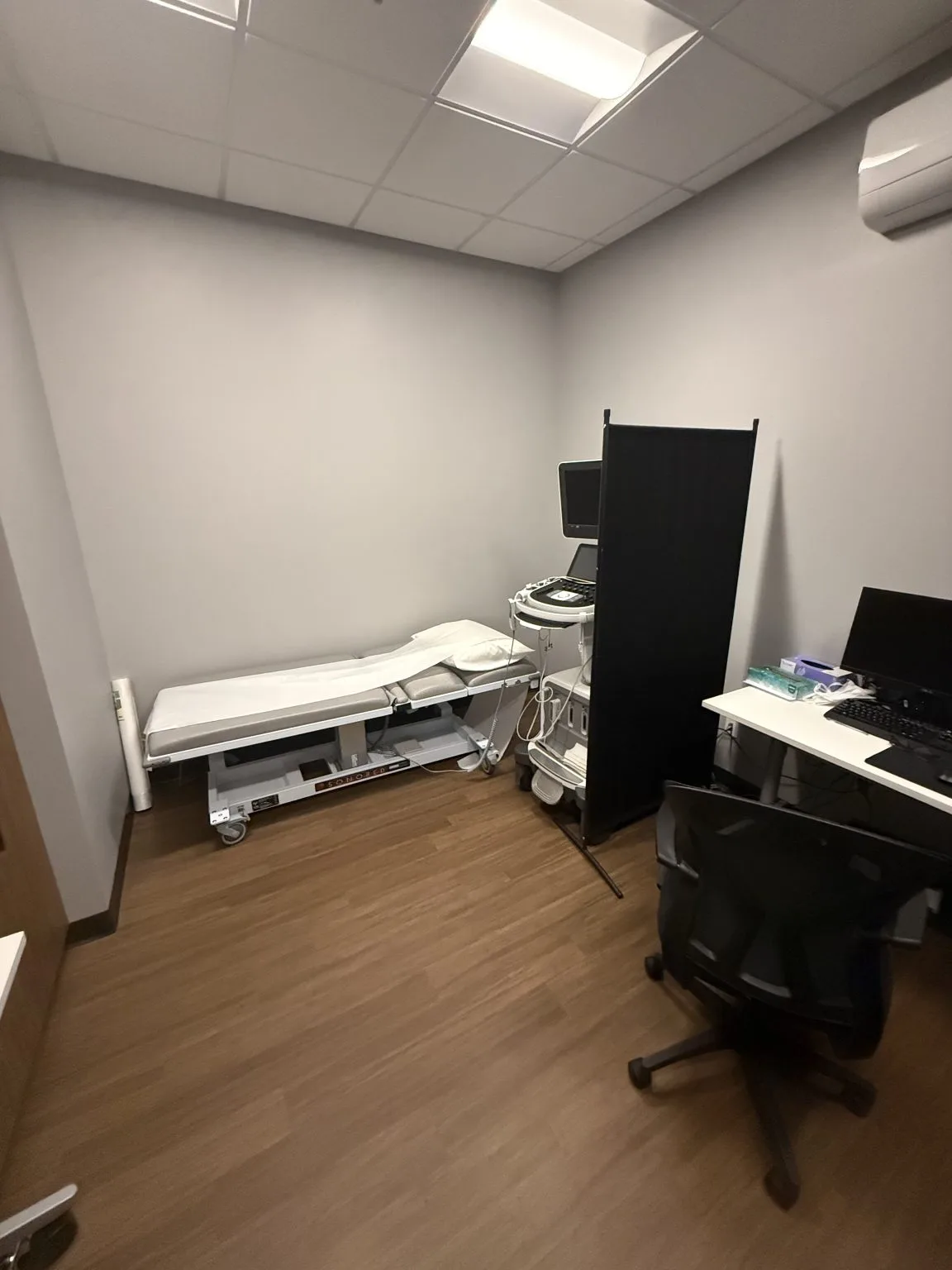 An echocardiography room with the ultrasound cart and examination bed