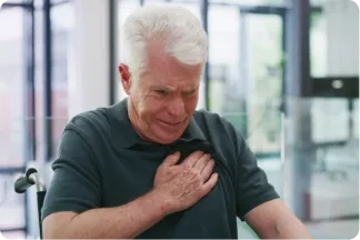 A patient holding their chest, one of the ways heart failure is first noticed